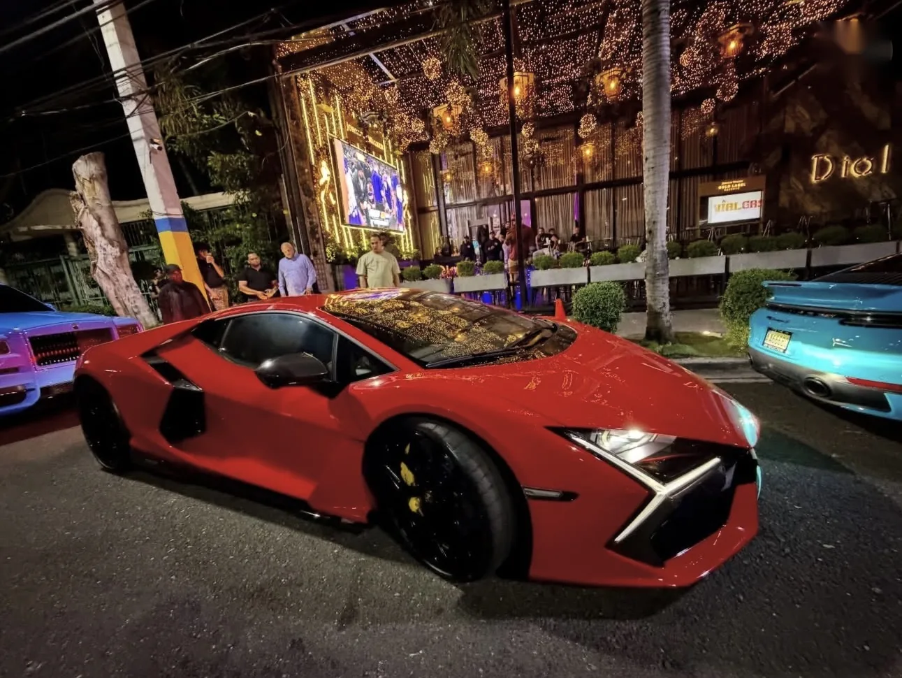 Lamborghini rojo frente a la fachada iluminada de Dial