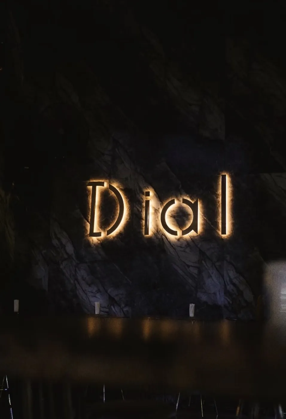 Letrero iluminado de Dial sobre una pared de mármol